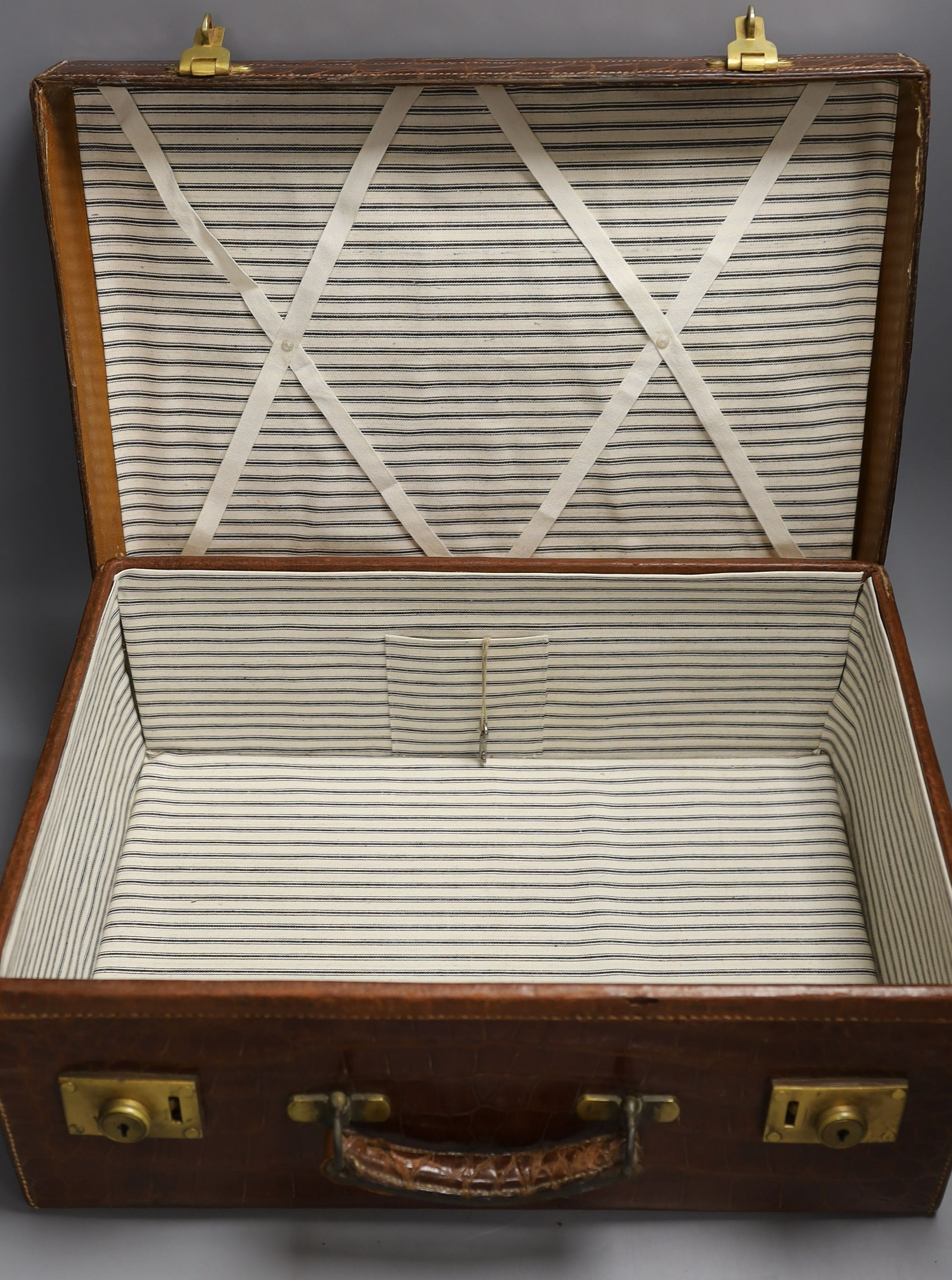 Two early 20th century crocodile hide suitcases, largest 48cms wide x 33 cms deep x 19cms high.